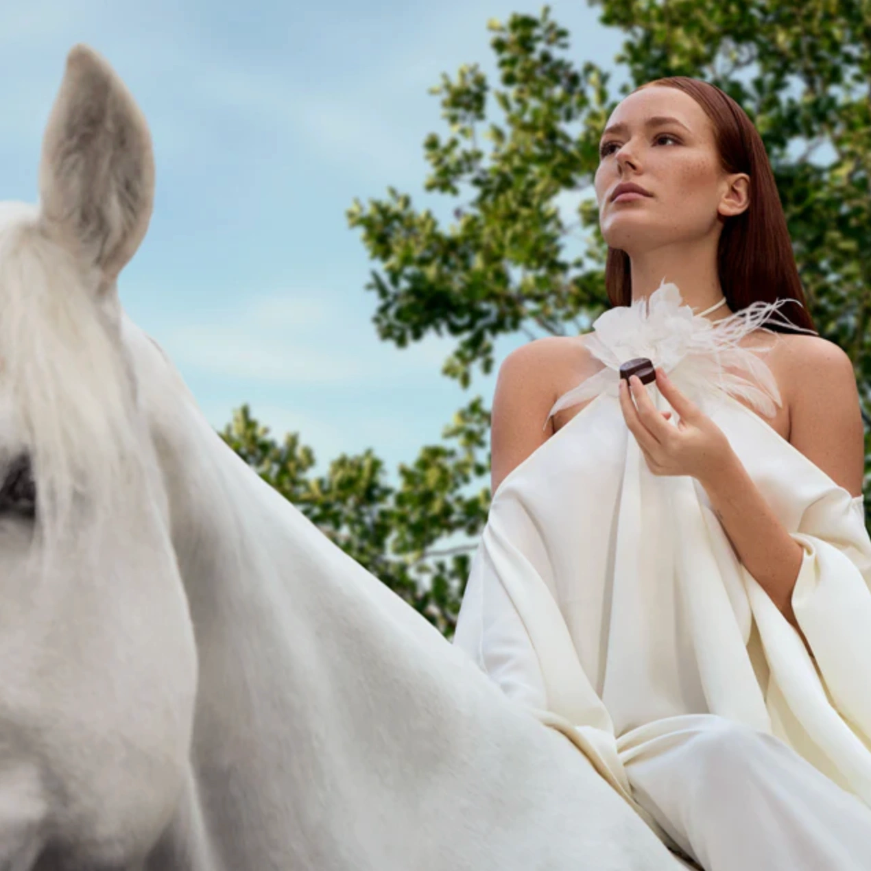 Woman eating Godiva chocolates on white horse