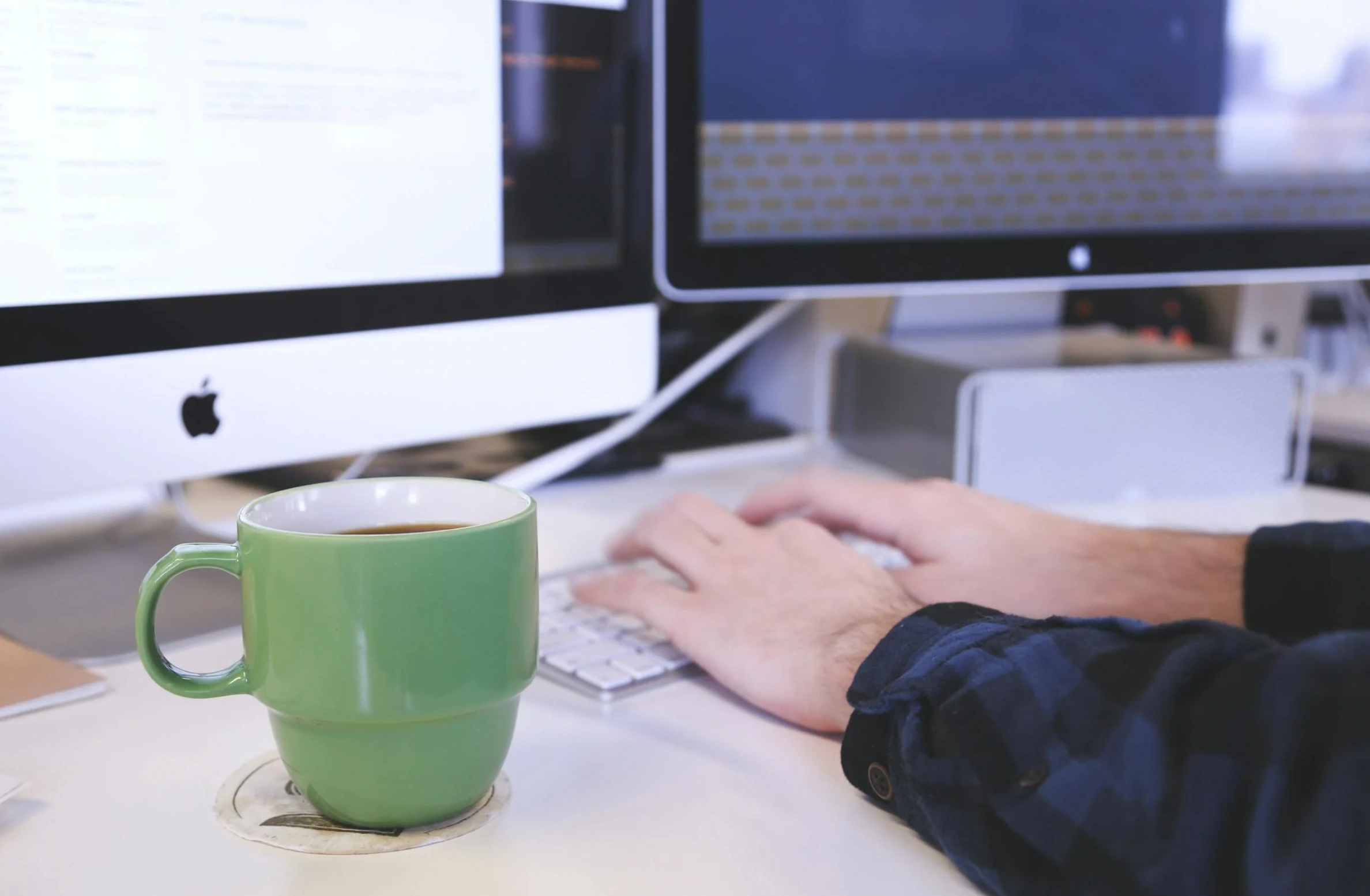 person working on 2 PCs