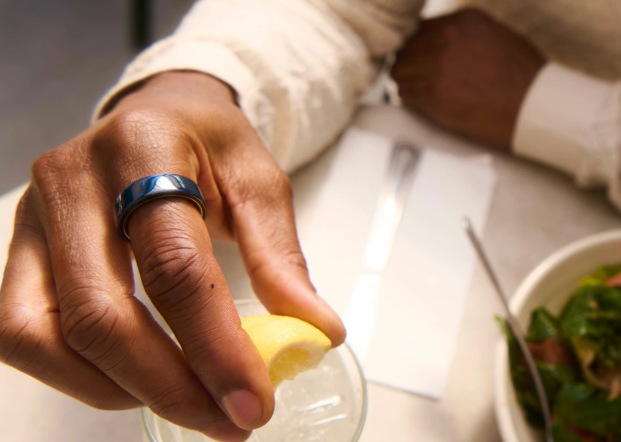 Man squeezing lemon with Oura ring
