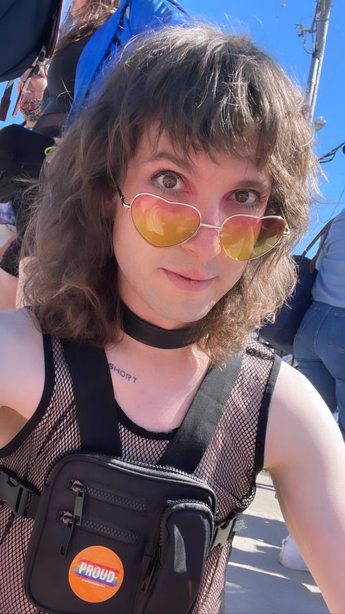 An Image of Clint wearing Heart-Shaped glasses and a black mesh shirt