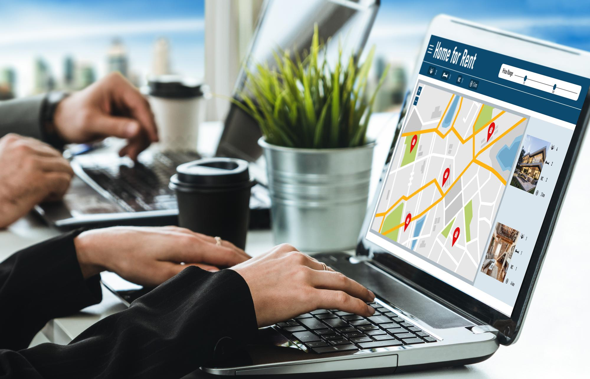 A professional using a laptop showing a city map with location pins, illustrating local SEO in digital marketing.