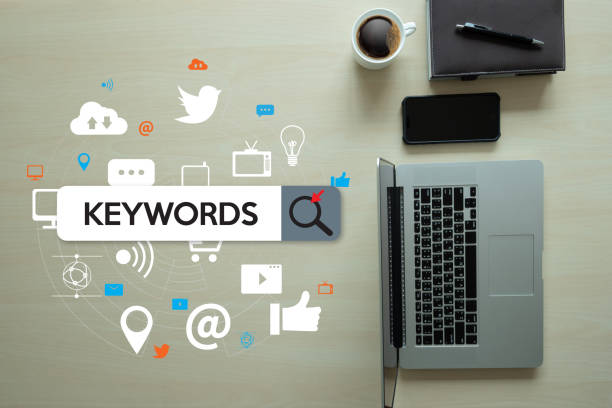 Keywords search bar surrounded by social media and digital marketing icons on laptop workspace.
