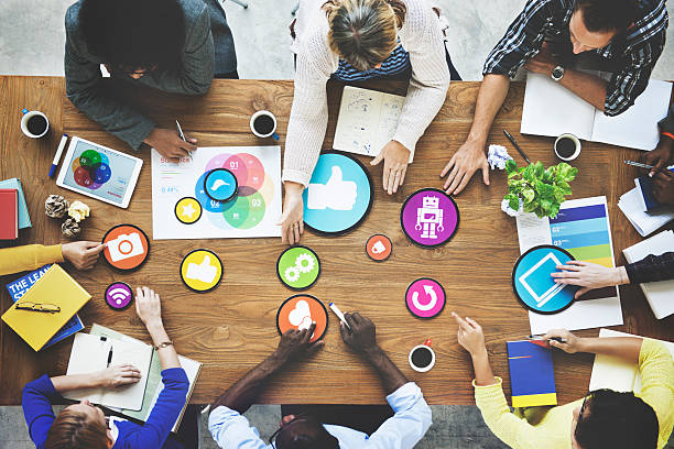 Diverse team collaborating on digital marketing strategy with social media icons on a meeting table.