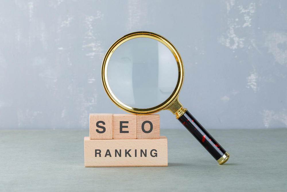 A magnifying glass leaning on buidling blocks that are making up the word SEO ranking.