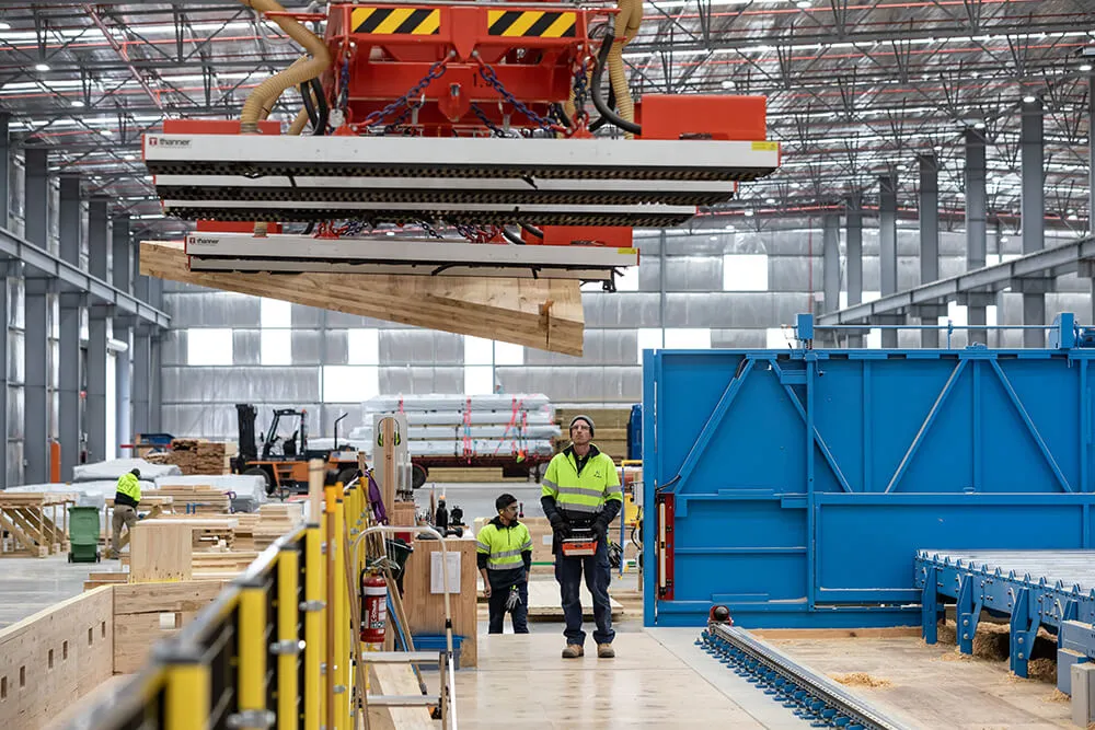 XLam employees using machinery to move CLT panels across the floor.