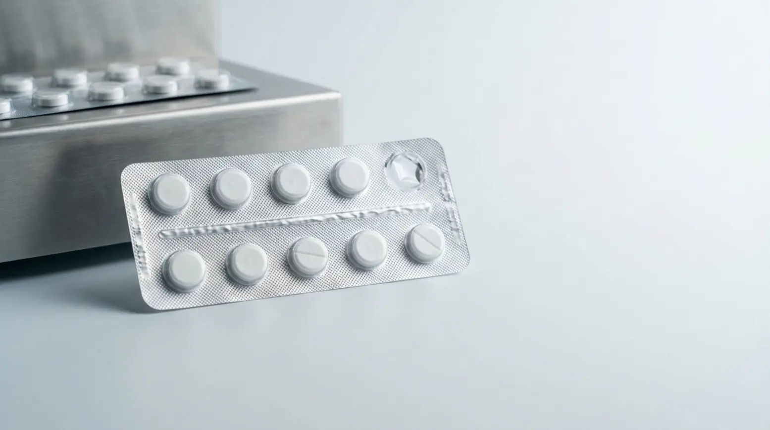 Photorealistic inspection of a pharmaceutical blister pack with a misaligned cavity on a grey surface.