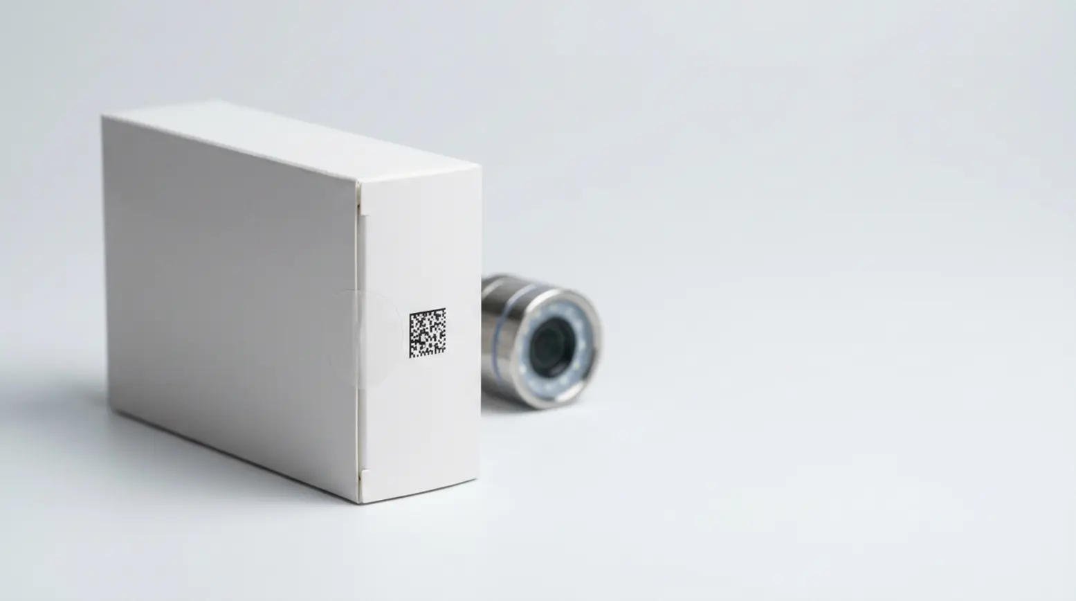 Photorealistic pharmaceutical carton with a DataMatrix code and tamper-evident seal on a soft backdrop.
