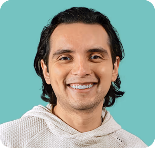 Retrato de Arturo Sánchez Correa sonriendo, vistiendo sudadera clara con fondo color verde aqua.