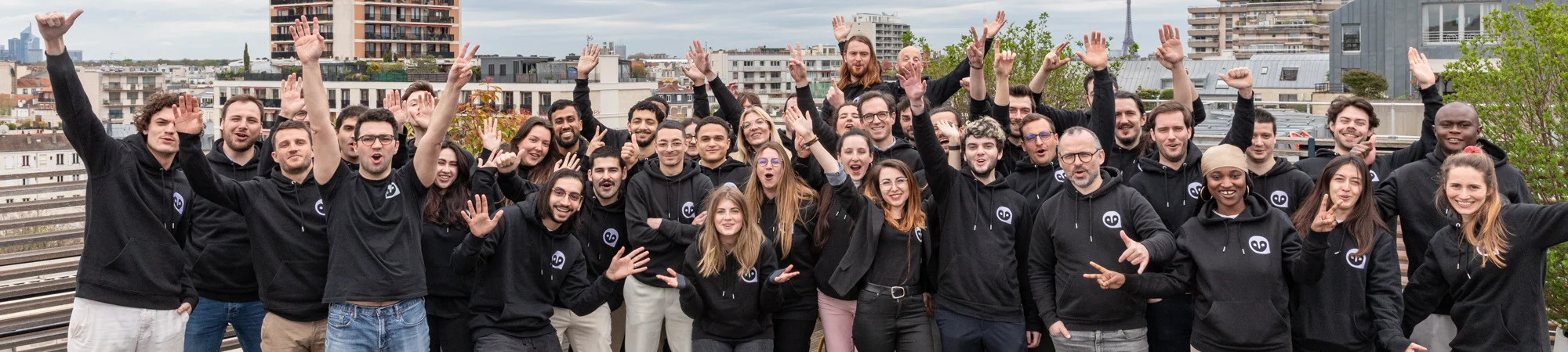 L'équipe de Kiliba souriant en sweat-shirts noirs avec le logo de la marque, posant sur le toit des locaux.