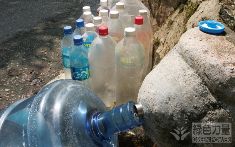 Lots of plastic bottles placed near water spring