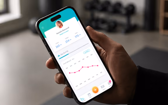 Activate Metabolics app dashboard shown on a phone, tracking weight-loss progress, held in a gym setting
