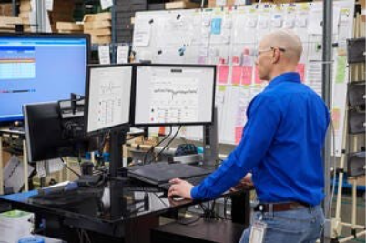 A person in a blue shirt working on a computerAI-generated content may be incorrect.