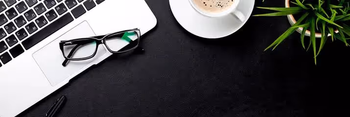 Flatlay of laptop with coffee and glasses