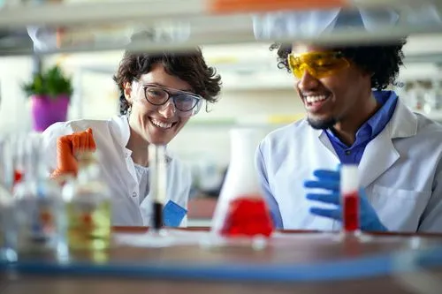 Female and male scientists looking at a beaker