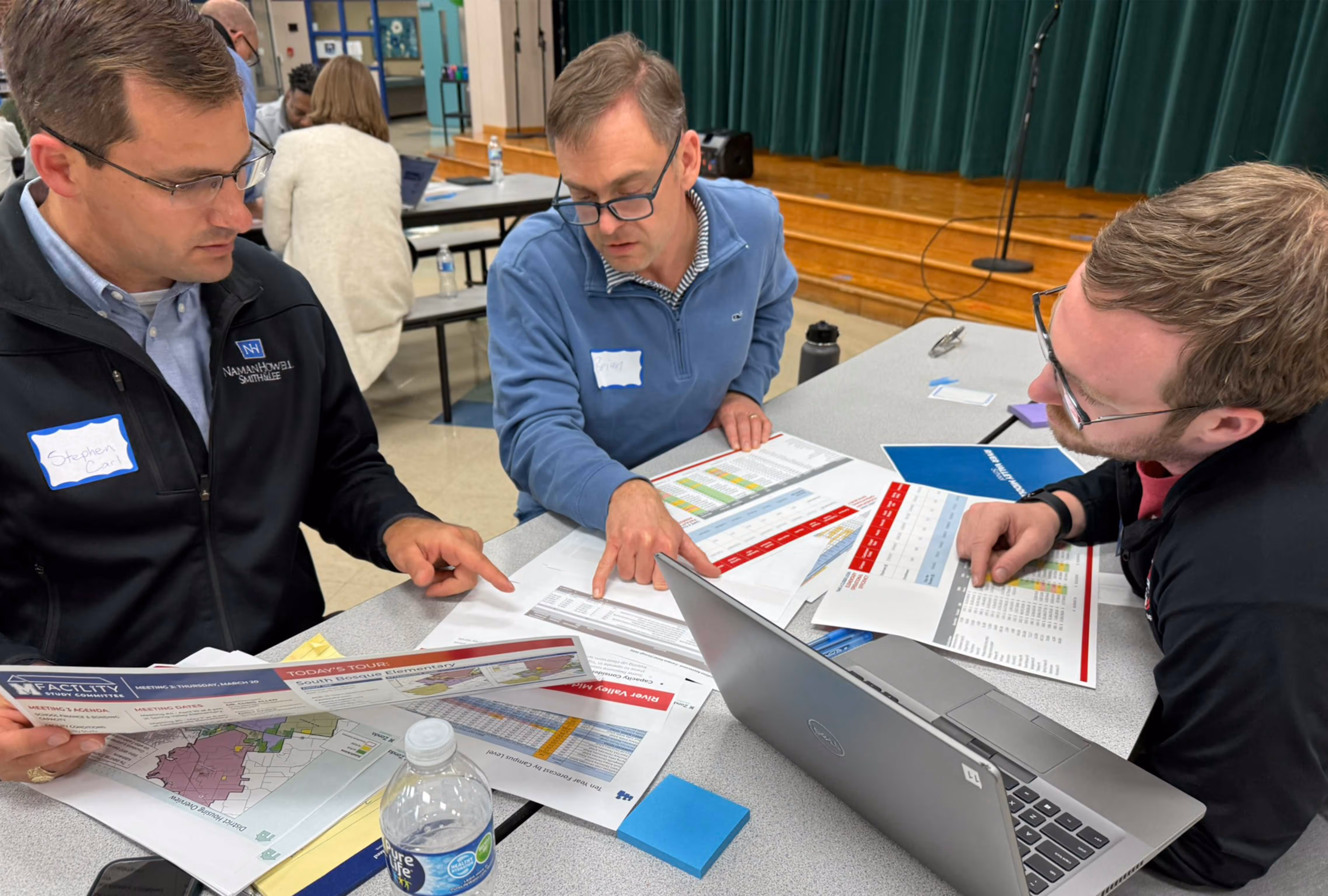 Three committee members reviewing charts.
