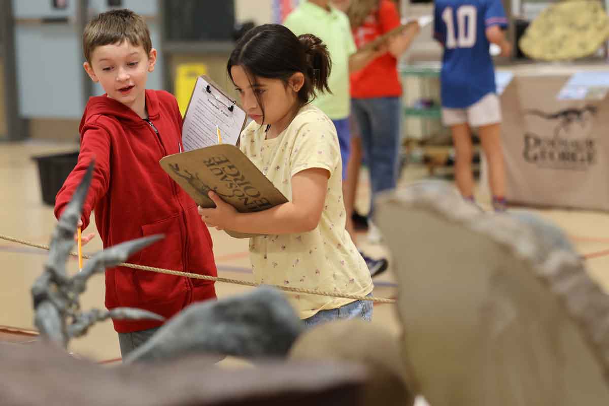 Students examine dinosaur fossils