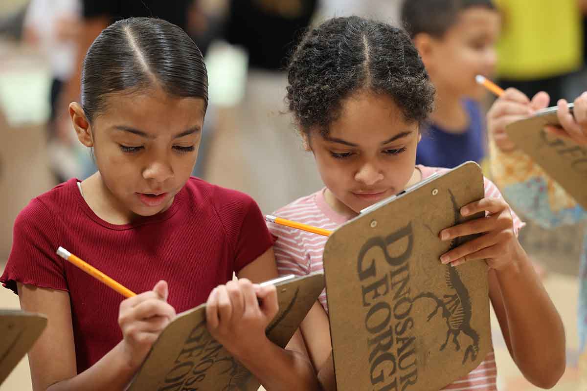 Students examine dinosaur fossils.