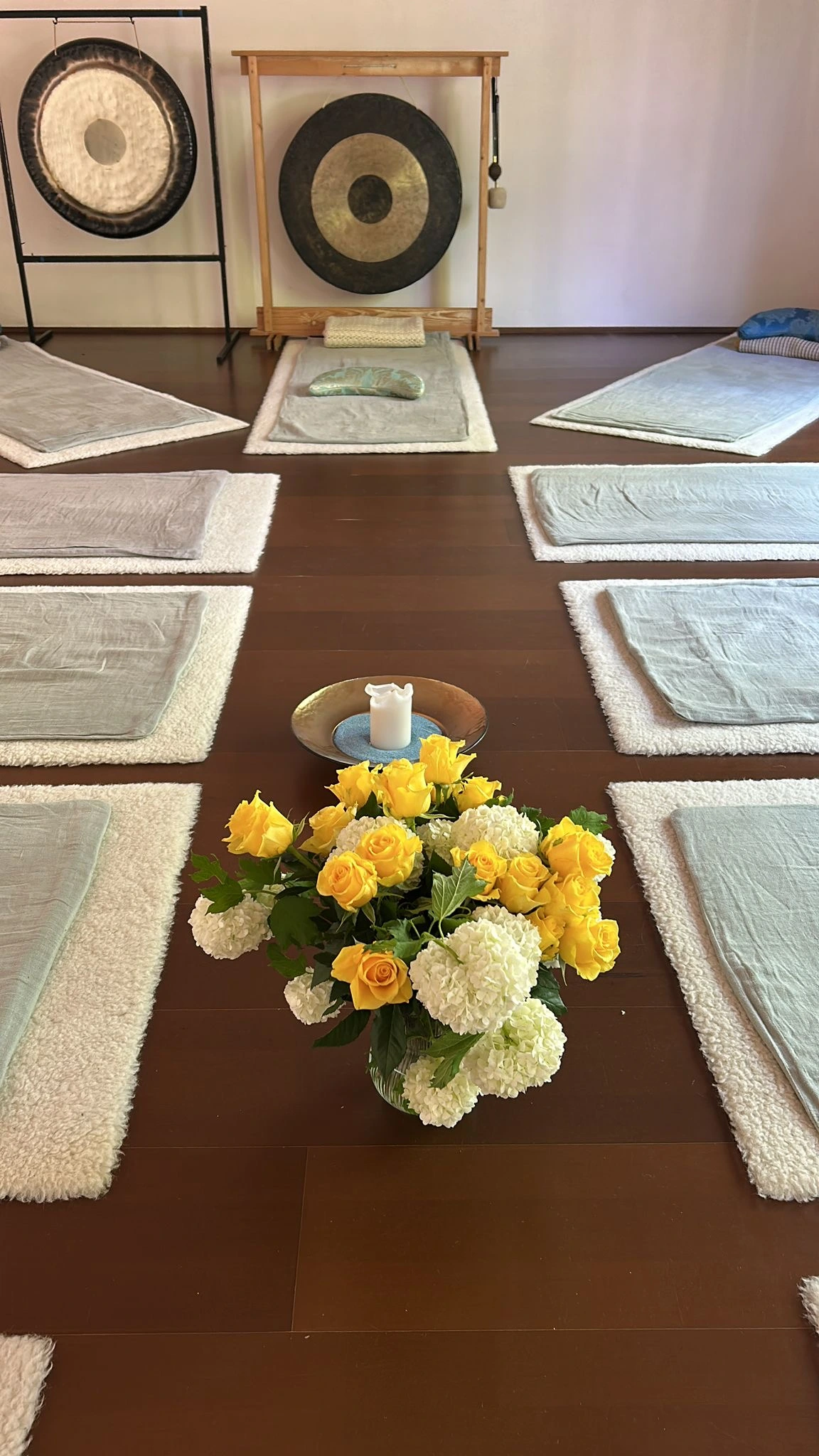 Ein Raum mit Matten ausgelegt, in der Mitte ein Strauss voller Blumen