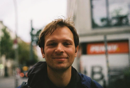 Portrait von Paul Maximilia Pira vor einem Gebäude