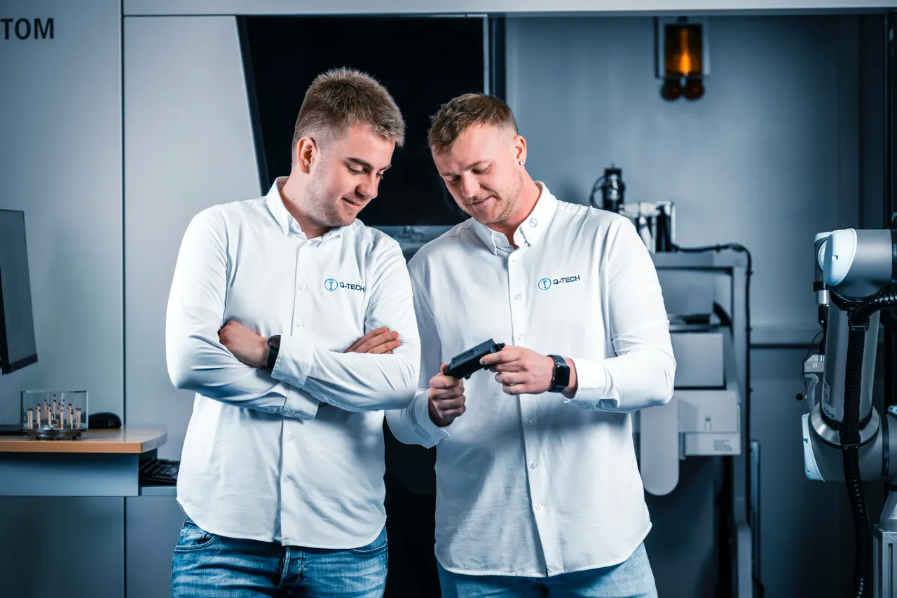 Zwei Mess-Experten von Q-Tech Roding begutachten ein Bauteil vor dem Computertomografen