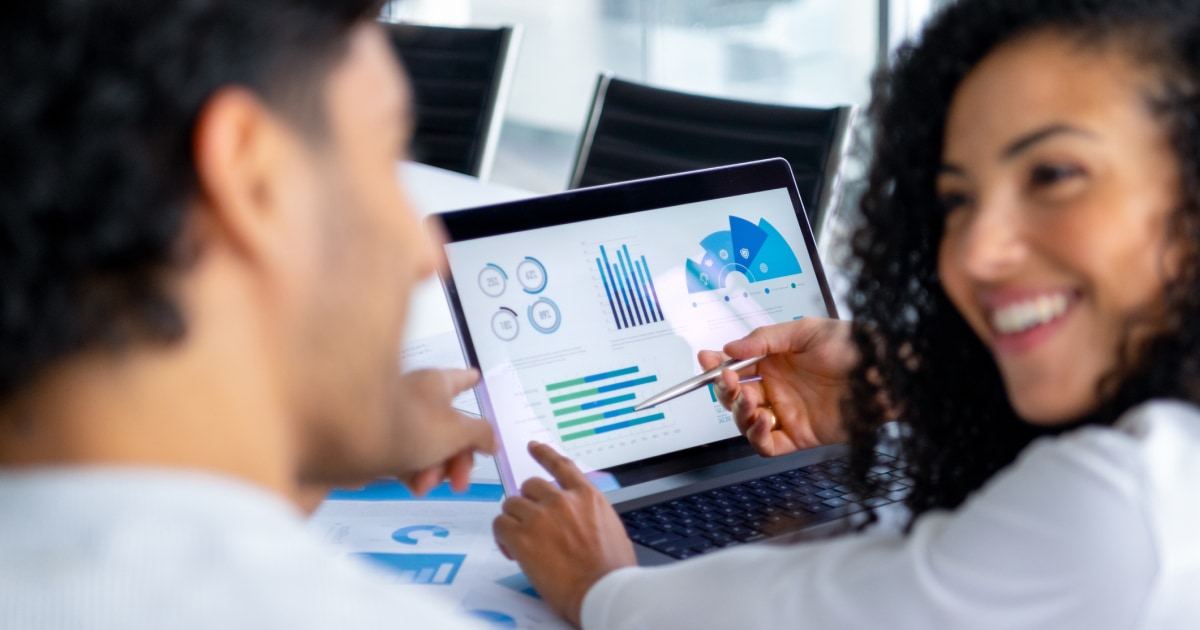 professionals discuss charts and metrics on tablet