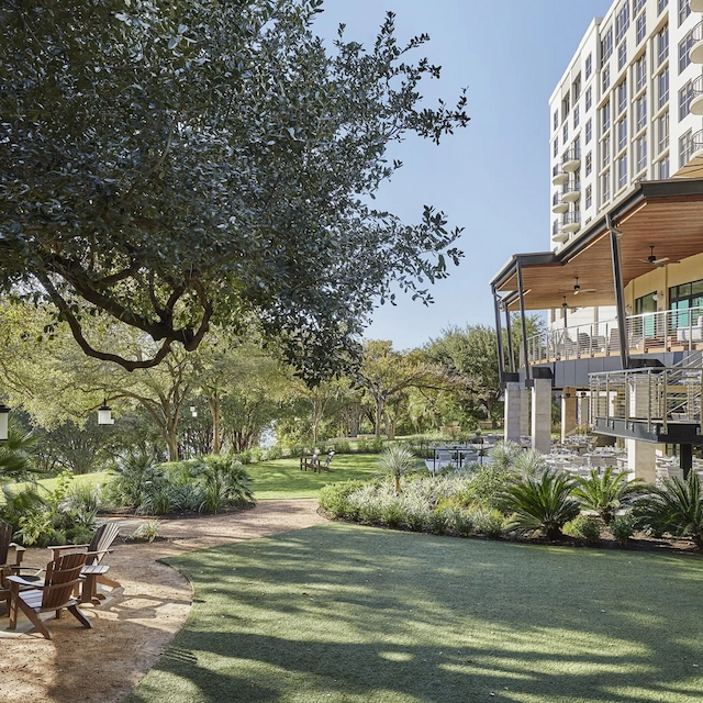Hotel garden with lawn, trees and outdoor seating