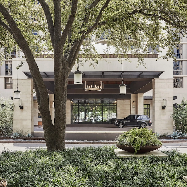 Hotel entrance framed by trees and landscaping