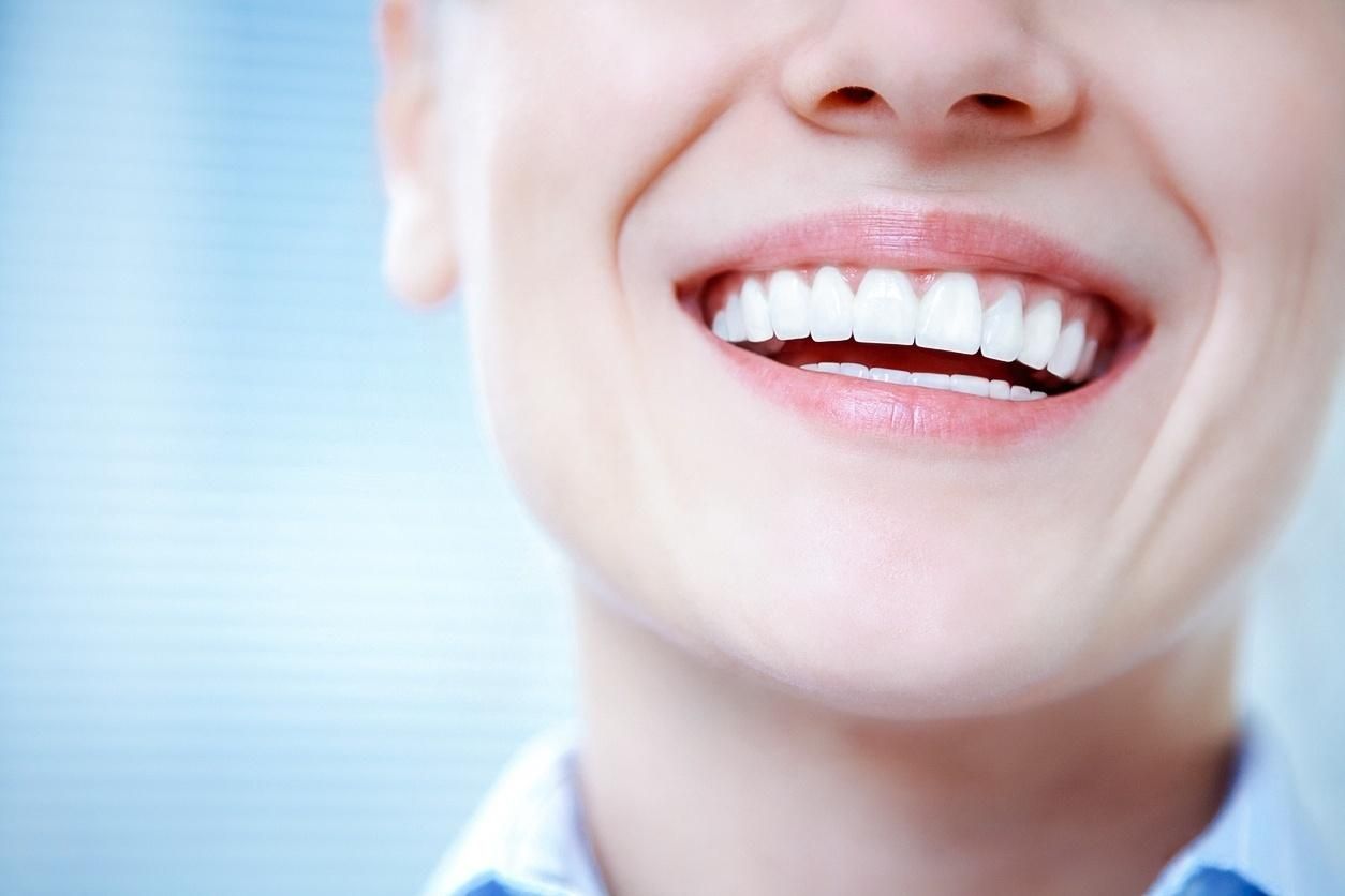 A Woman Smiling Confidently With Dental Implants That Keep Your Surrounding Teeth From Shifting, Giving You a Natural and Secure Look.