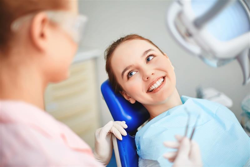 Endodontist and patient during a root canal consultation in the dental chair.