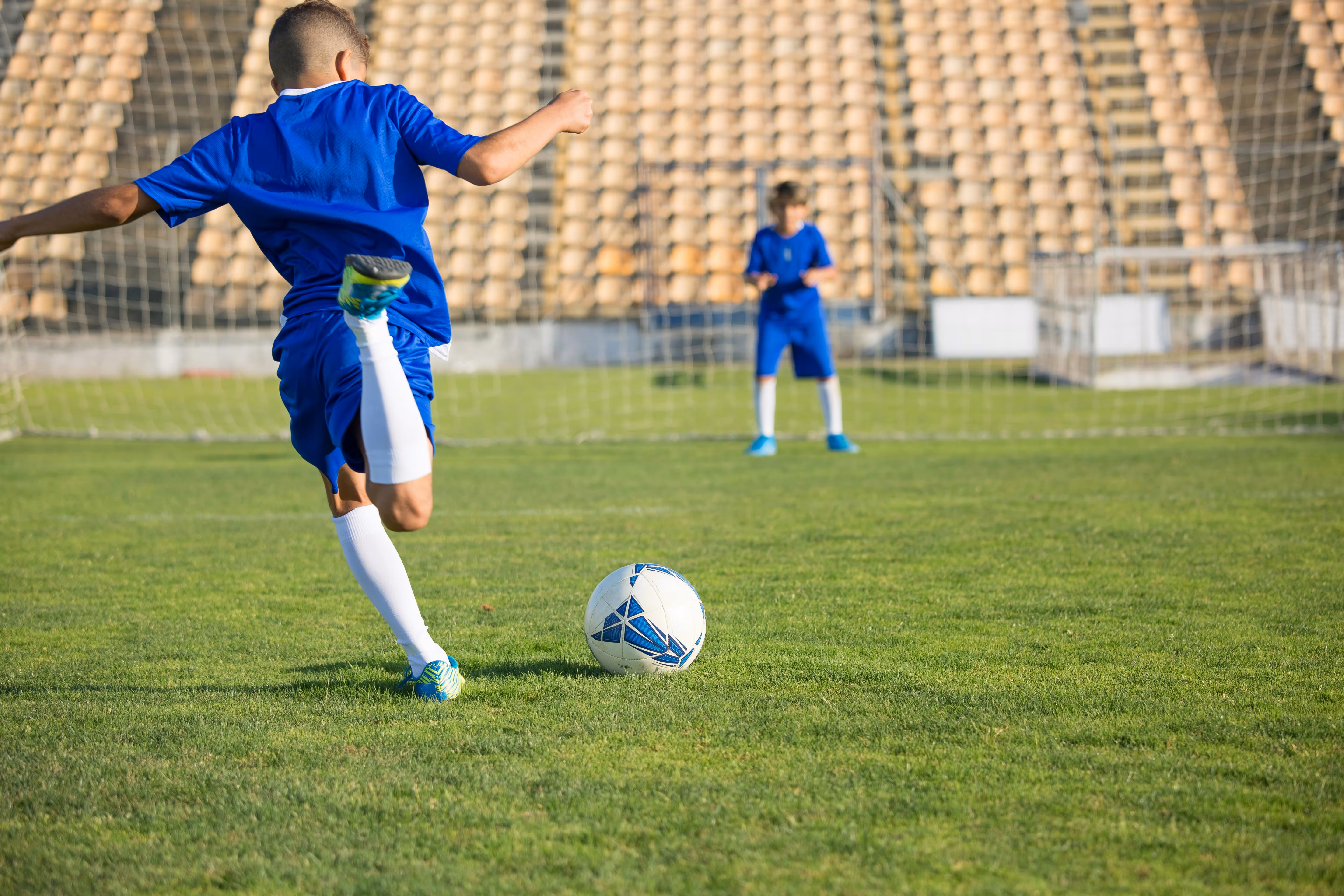 A young player practices a kick, illustrating the skill development supported by the Soccer Skills Pro app