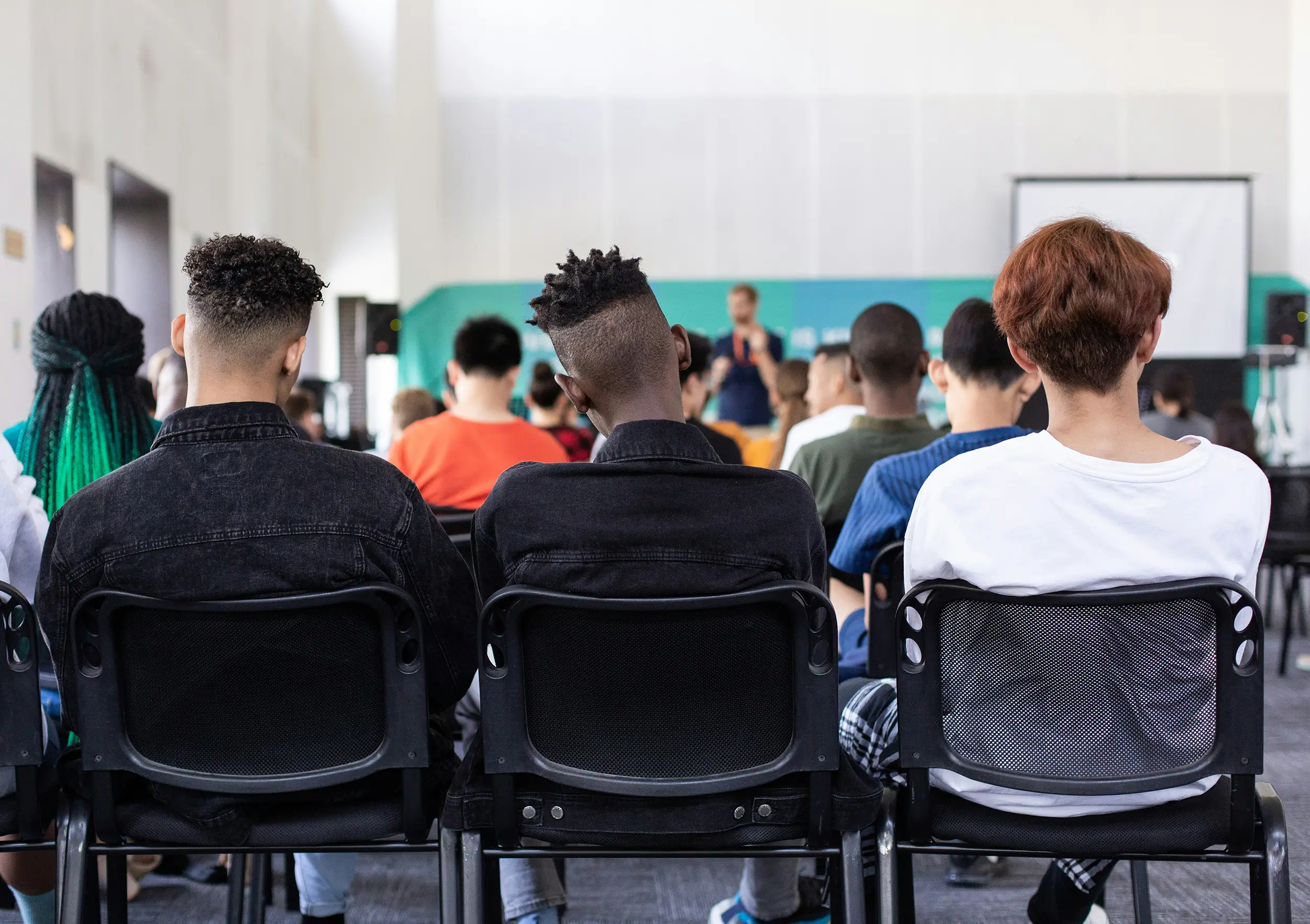 Teens sitting in chairs listening to school counseling program through Infinite Counseling & Wellness in Richmond, VA