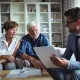 Cette image montre un couple senior examinant des documents avec leur conseiller