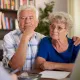 Cette image montre un couple senior écoutant leur conseiller
