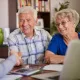Cette image montre un couple senior assisté de leur conseillère
