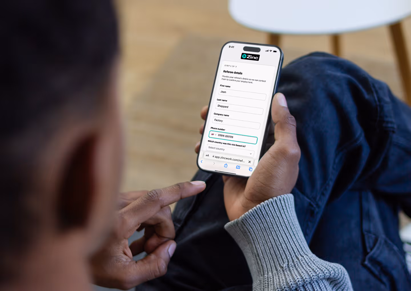 Person completing a Zinc referee details form on mobile