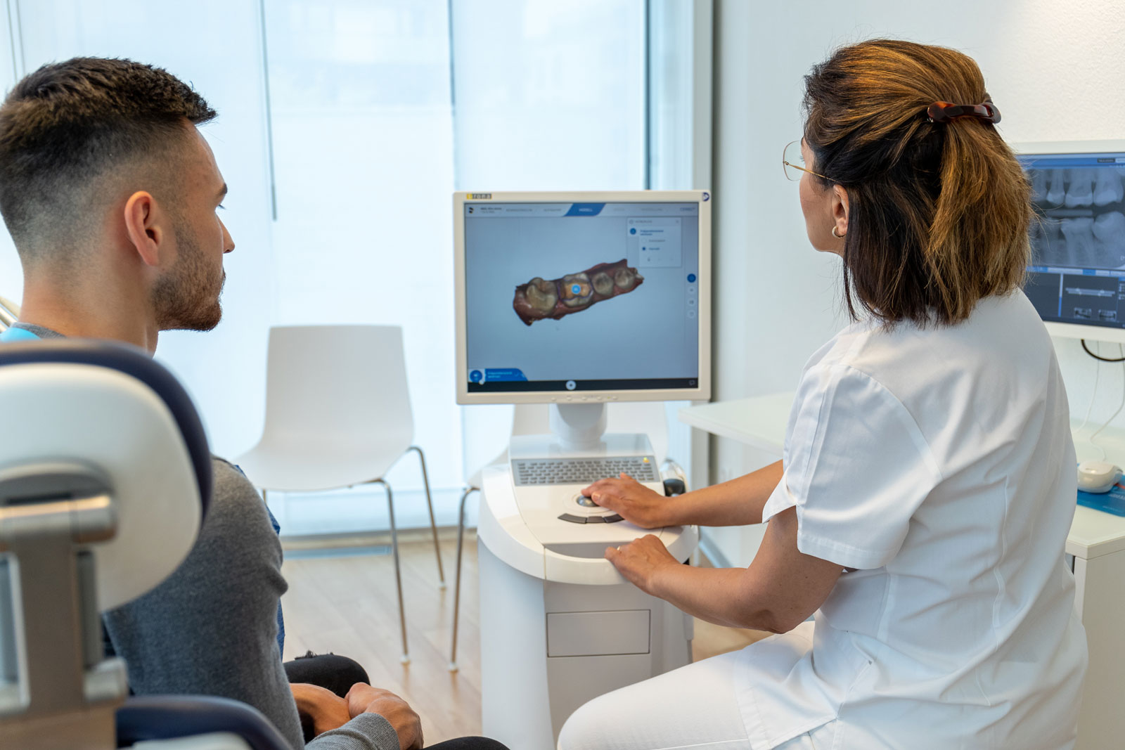 Dr. Farspour berät einen Kunden zur Zahnfüllung. Zahnfüllungen aus Komposit oder Keramik überzeugen durch ein ästhetisches Ergebnis.