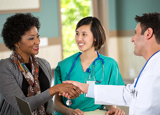 Doctor shaking patient's hand at front desk