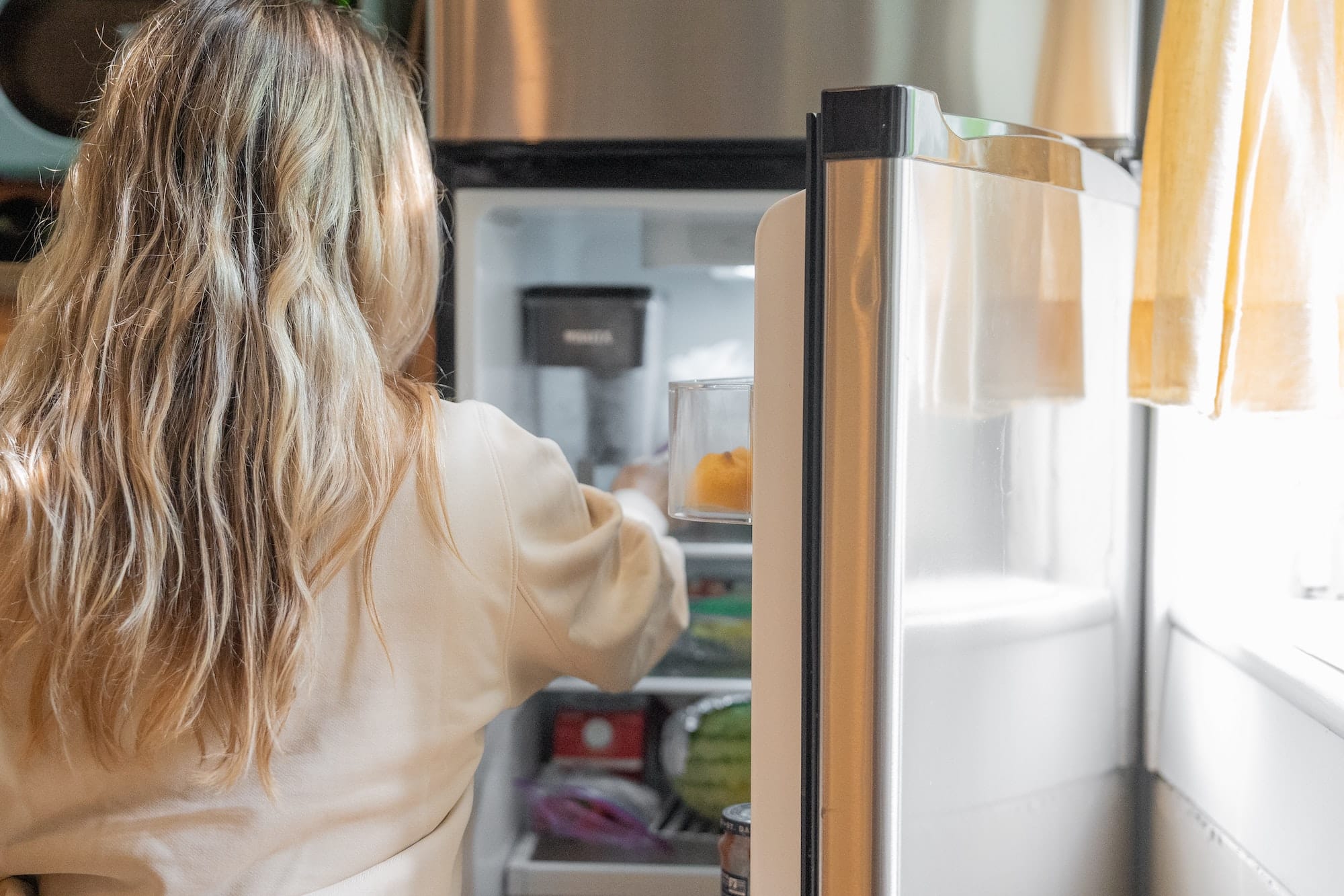 woman looking in a refrigerator 
