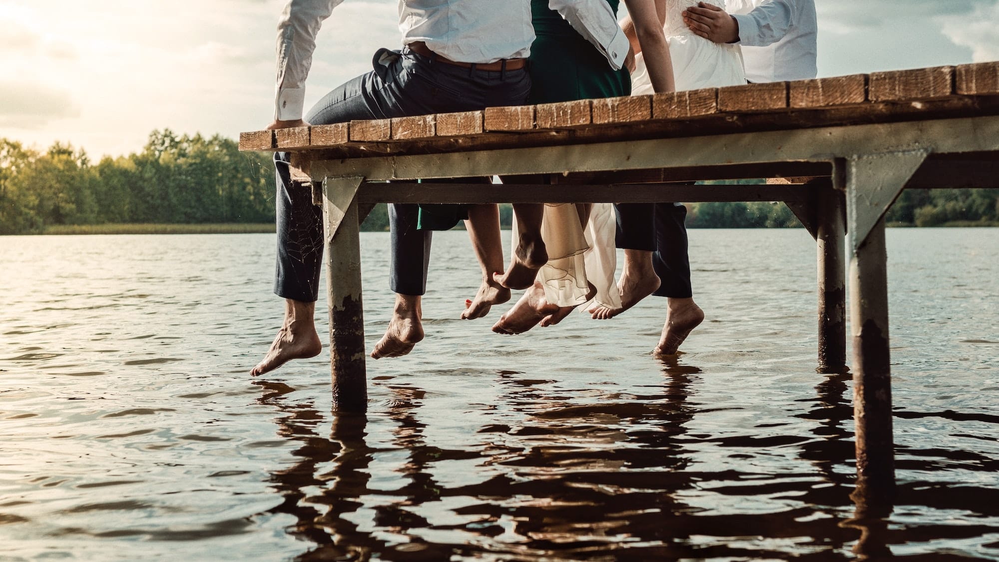 people sitting on a dock on a lake