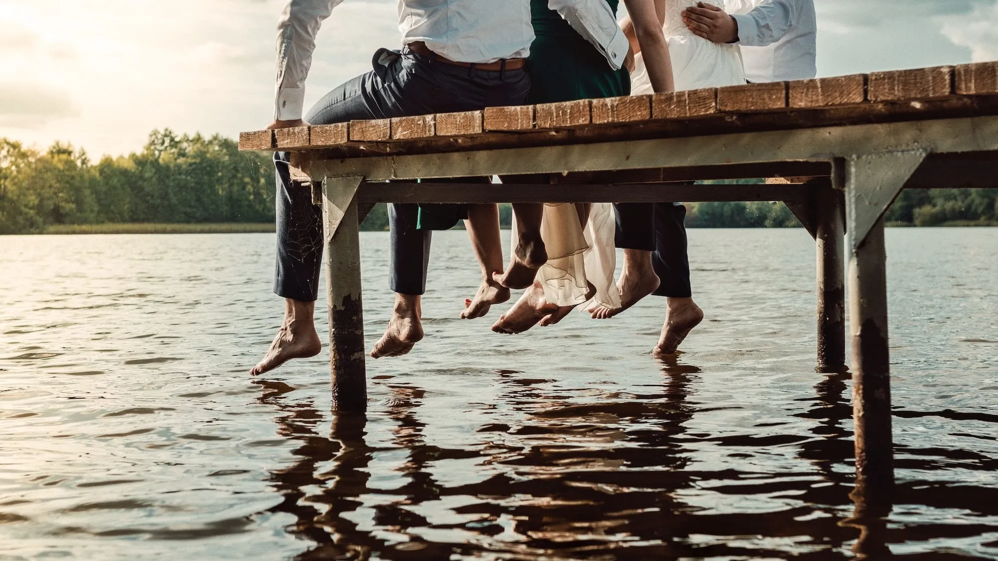 people sitting on a dock on a lake