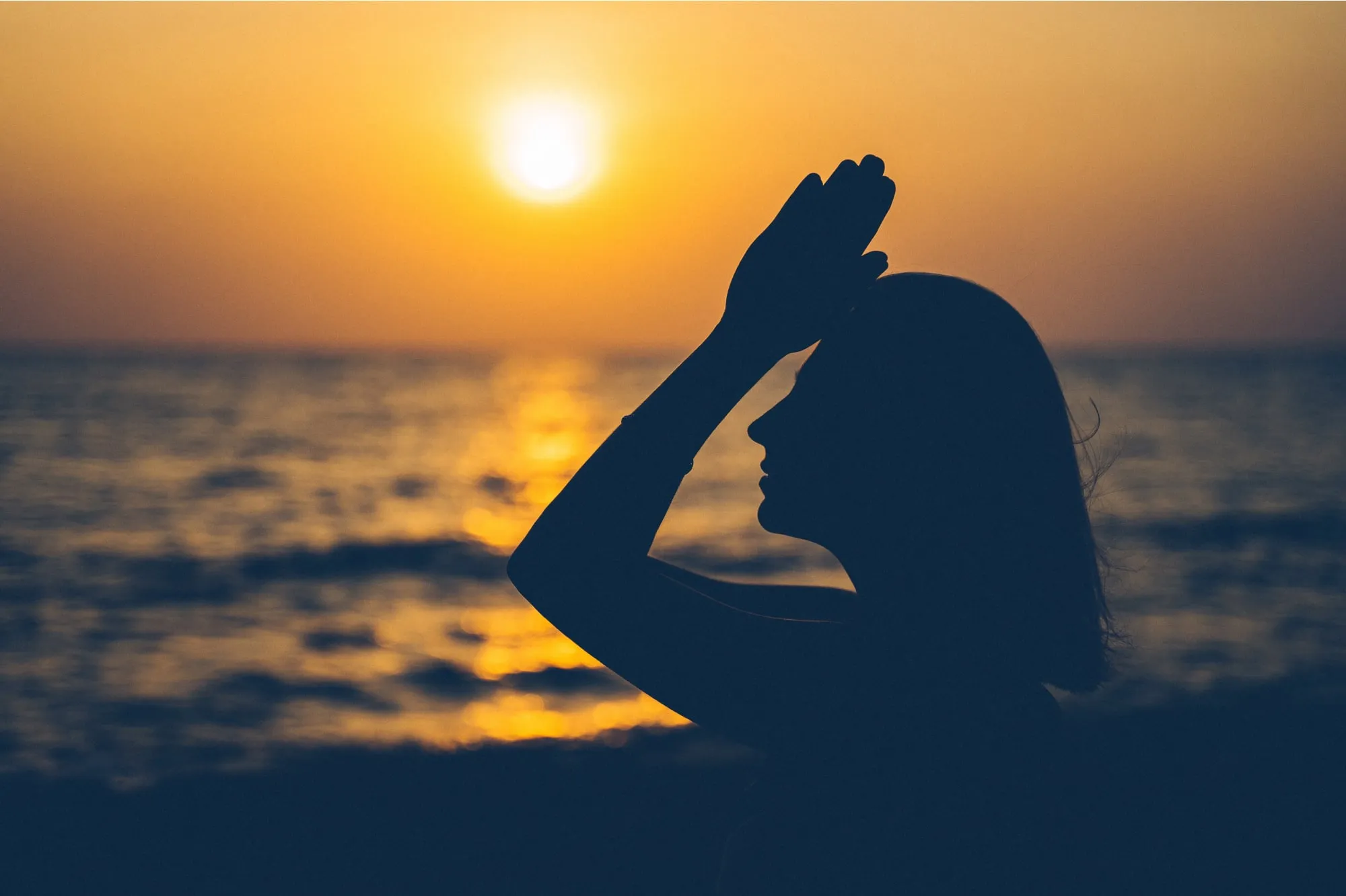Woman meditating on the beach
