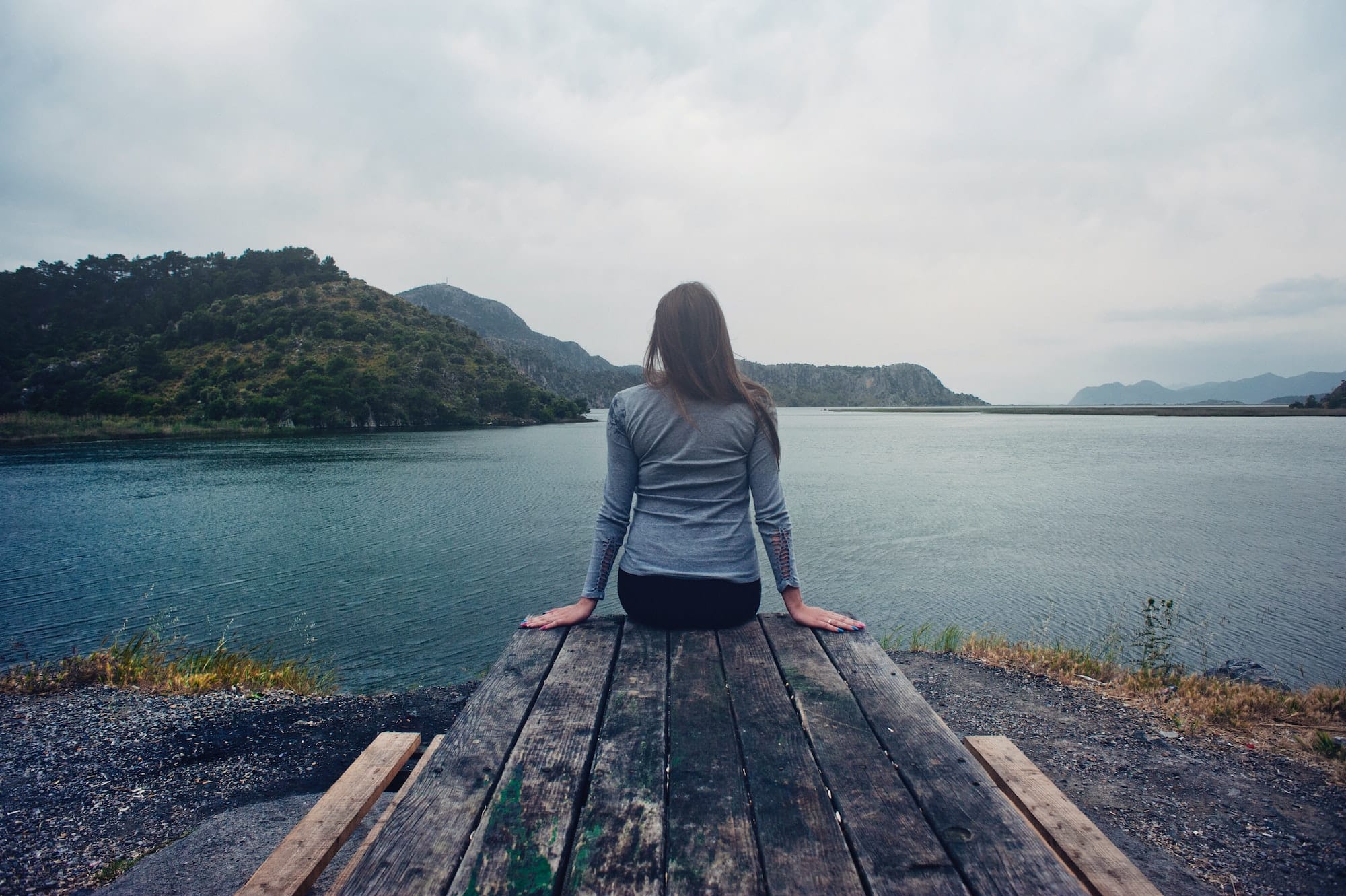woman sitting looking out at water