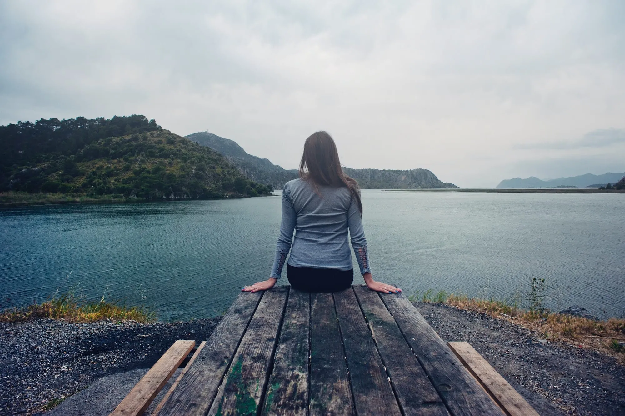 woman sitting looking out at water