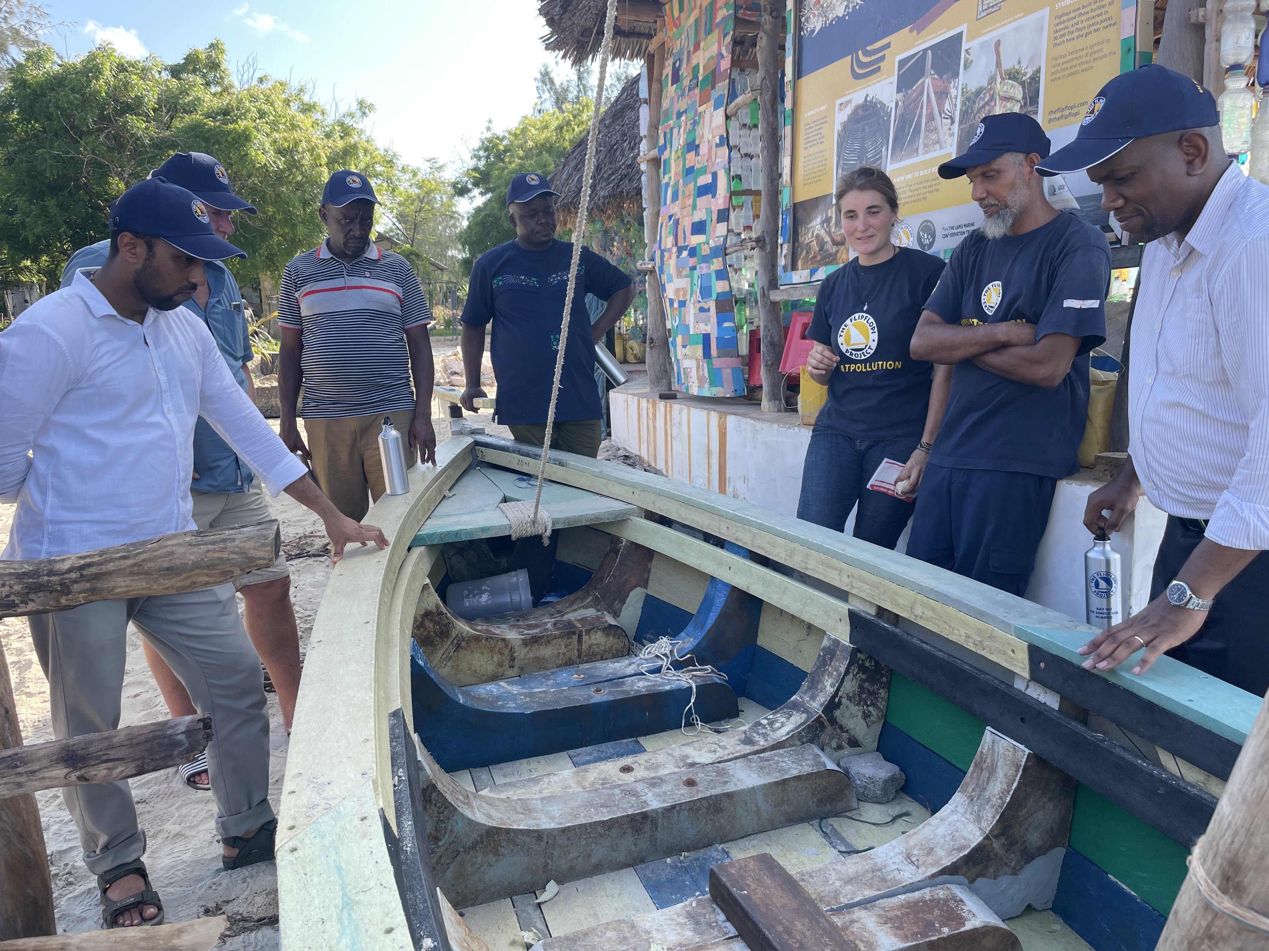 a group of people standing around a boat