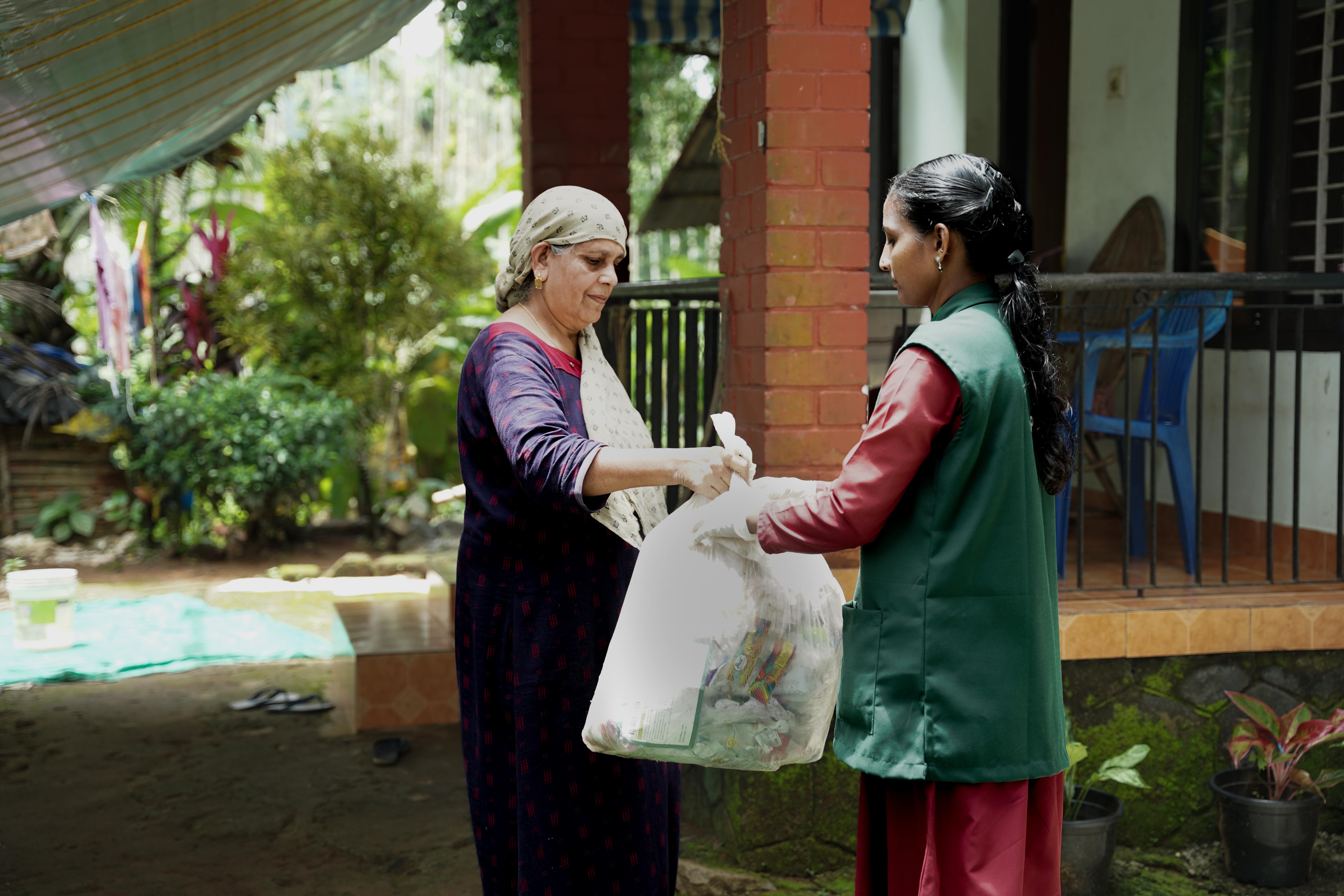 a woman handing a plastic bag to another woman