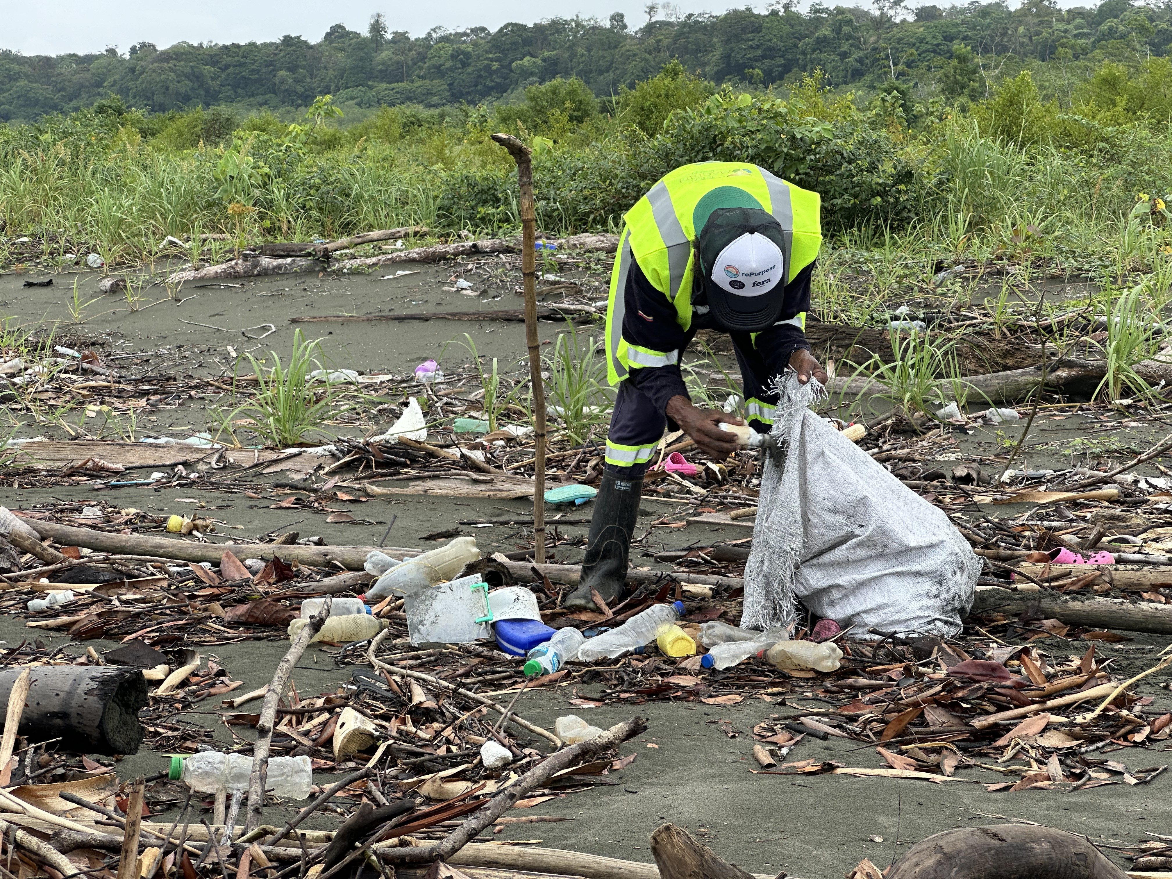 a man in a reflective vest picking up trash