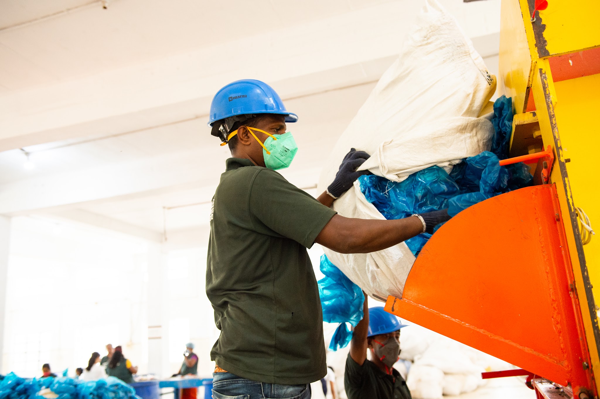 a man wearing a mask and gloves holding a bag of bags