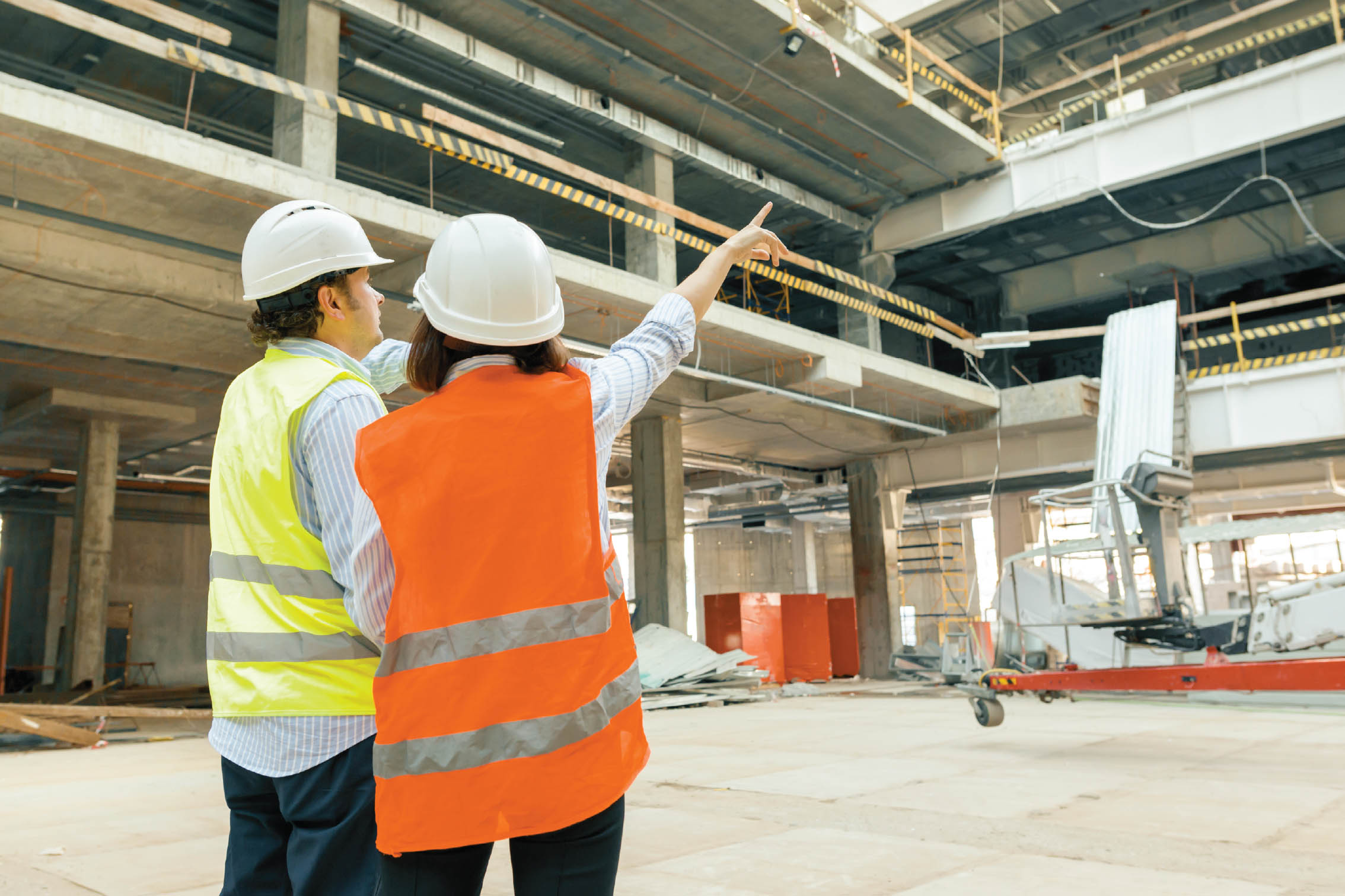 Construction site manager completing a digital QA checklist on a tablet during an inspection walk.