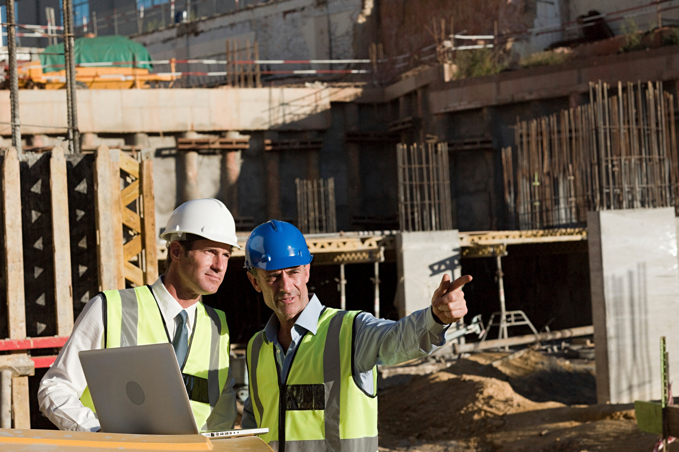 Tier 1 construction professional reviewing digital compliance data across multiple projects.