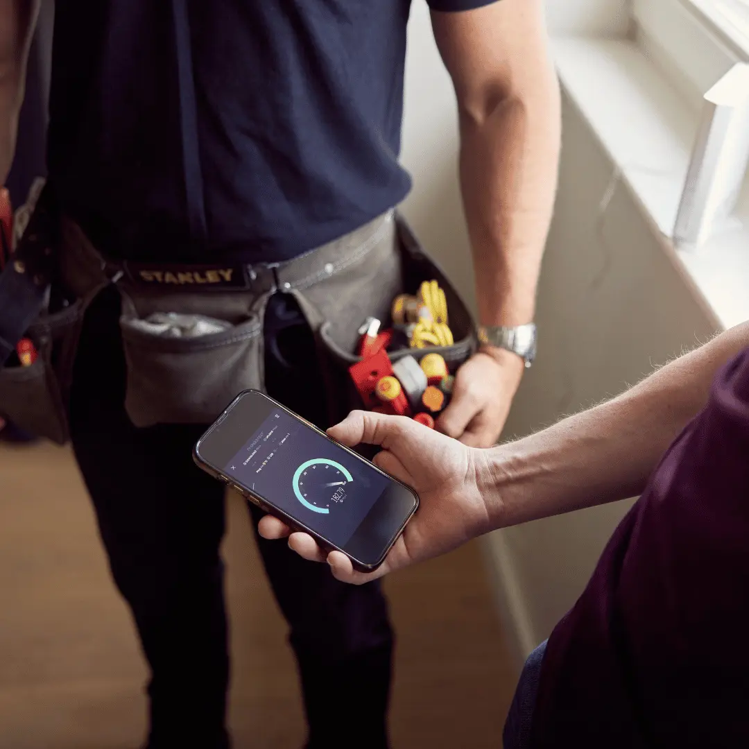 Bewoner controleert de verbinding in de app terwijl de monteur meekijkt
